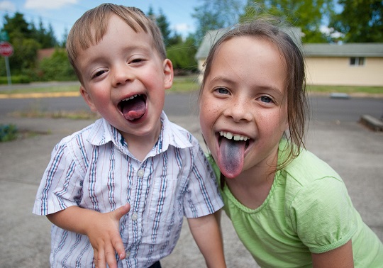 Dos niños sacando la lengua